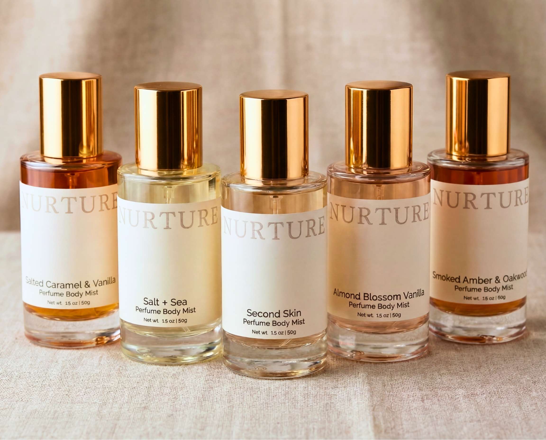 A row of Nurture perfume body mists on a linen surface.
