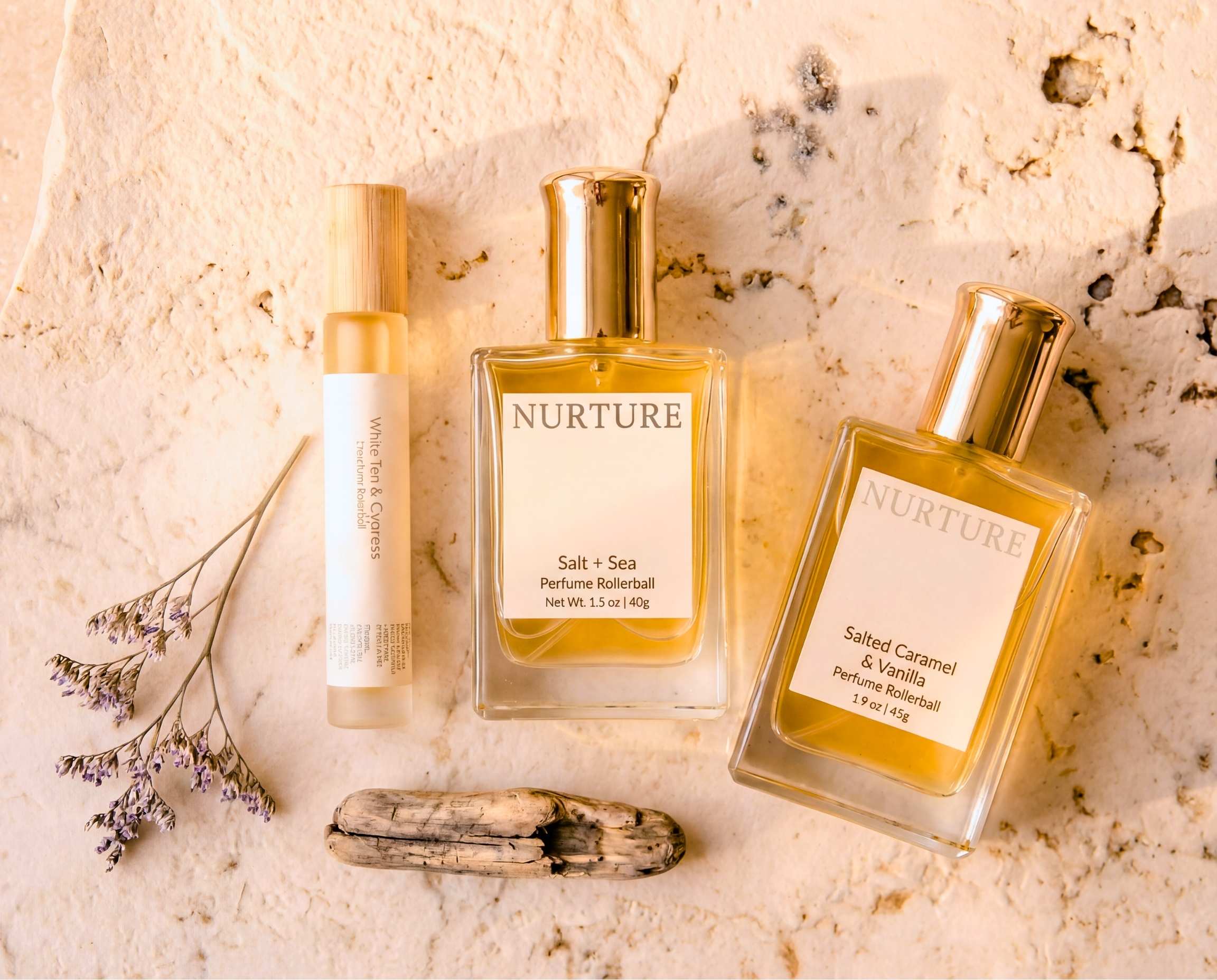 Collection of Nurture perfume rollerballs on a light stone surface.