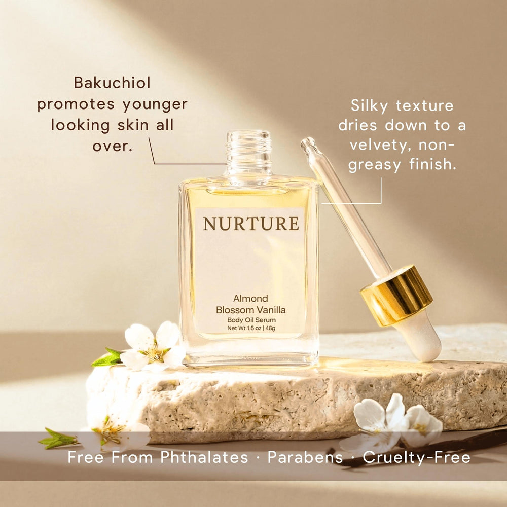 Nurture Almond Blossom Vanilla body oil serum with dropper on a stone surface with flowers.