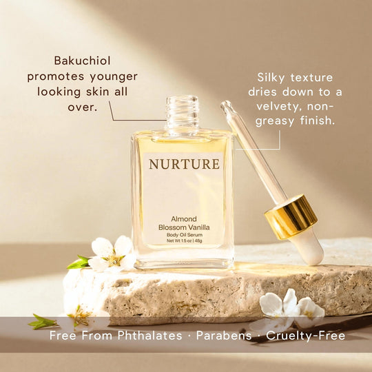 Nurture Almond Blossom Vanilla body oil serum with dropper on a stone surface with flowers.