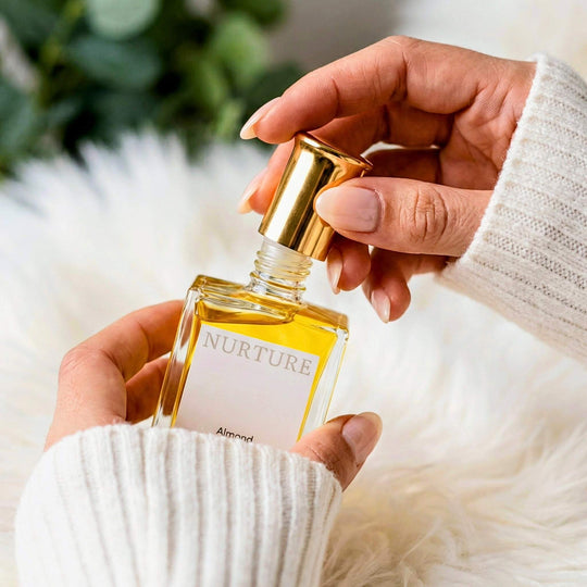 Hand holding a perfume bottle labeled &