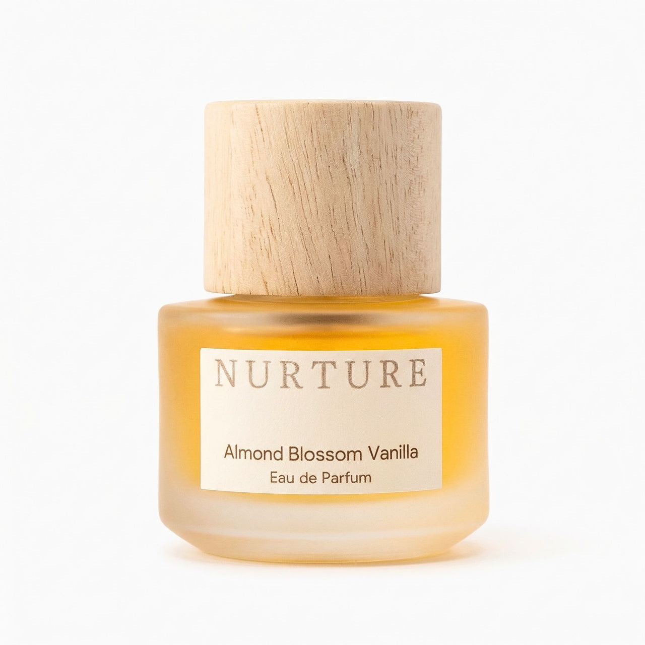 Bottle of 'Nurture Almond Blossom Vanilla' eau de parfum with wooden cap on a white background
