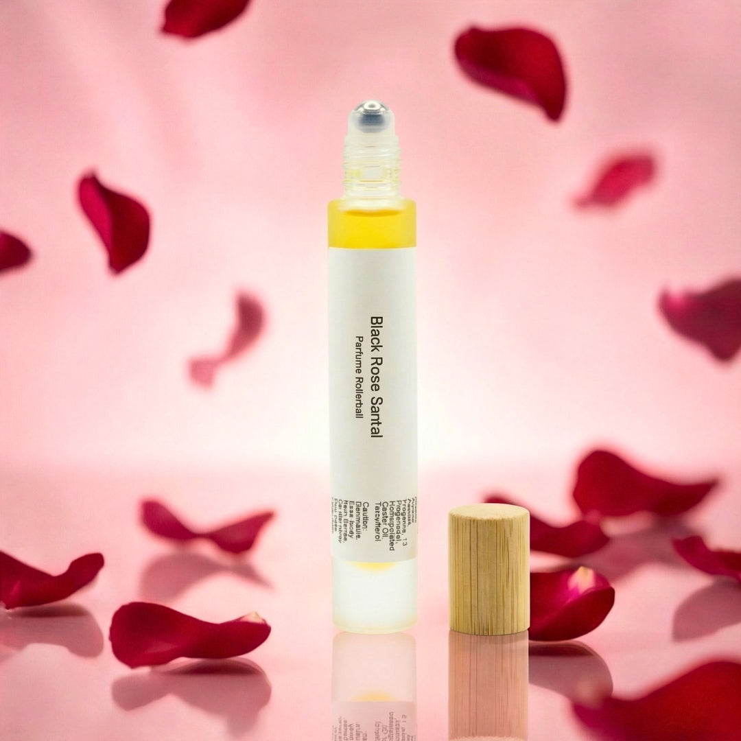 Black Rose Santal rollerball on a pink background with rose petals.