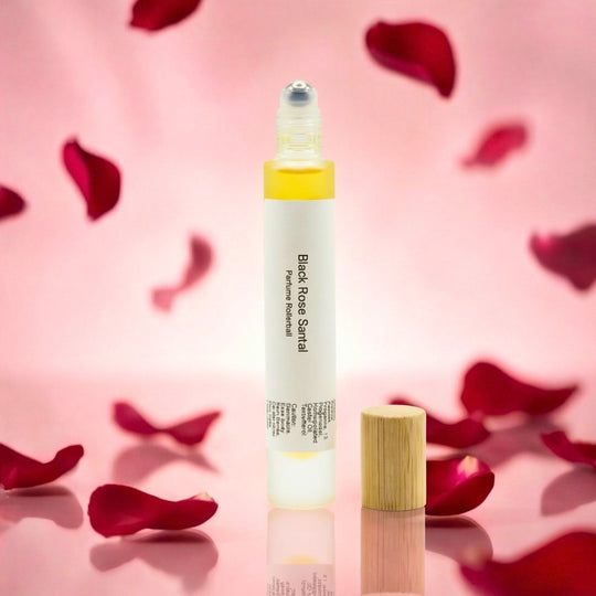 Black Rose Santal rollerball on a pink background with rose petals.