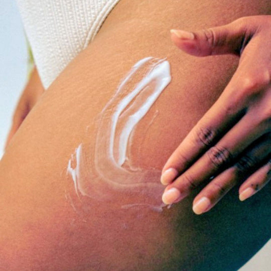 Woman applying Nurture Body Lotion to her thigh.