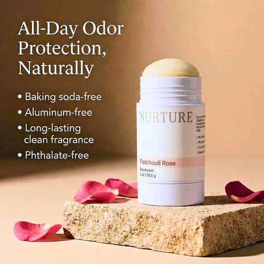Patchouli Rose deodorant on a stone surface with pink petals, against a warm background.