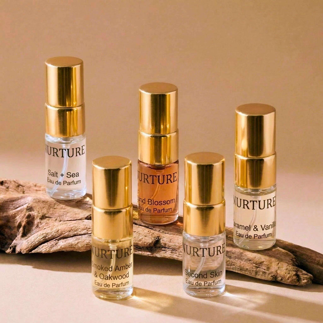 Set of Nurture perfume bottles with gold caps on a beige background