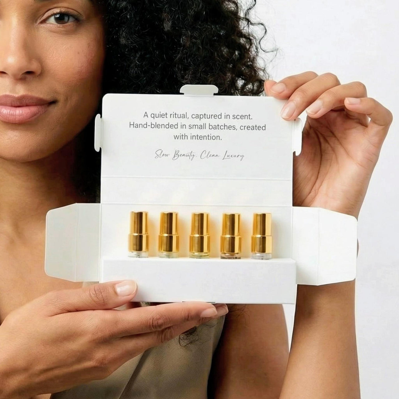 Woman holding an open Clean Perfume Discovery Kit box.