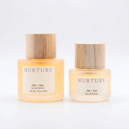 Two bottles of NURTURE Salt + Sea Eau de Parfum on a light gray background