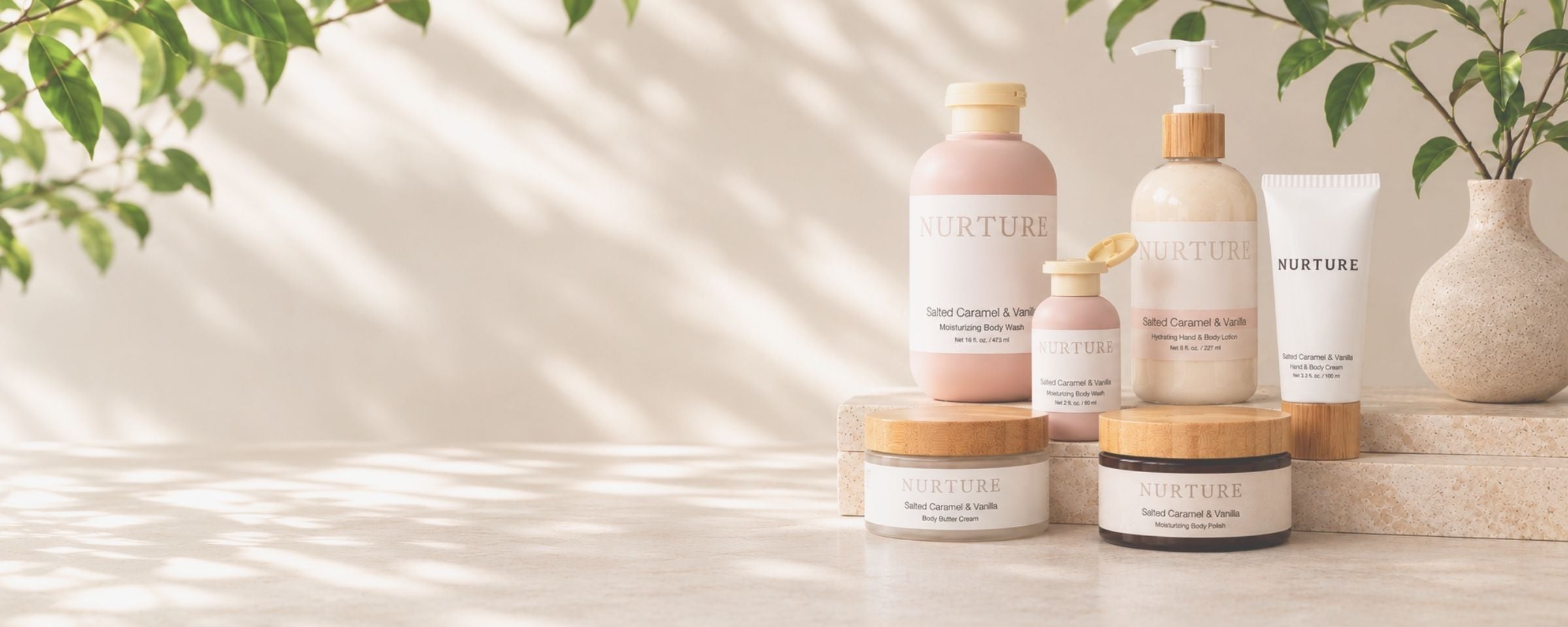 A set of NURTURE skincare products including a pump bottle, a tube, and jars with bamboo lids, arranged on a light stone surface with soft leaf shadows and a vase of greenery in the background.