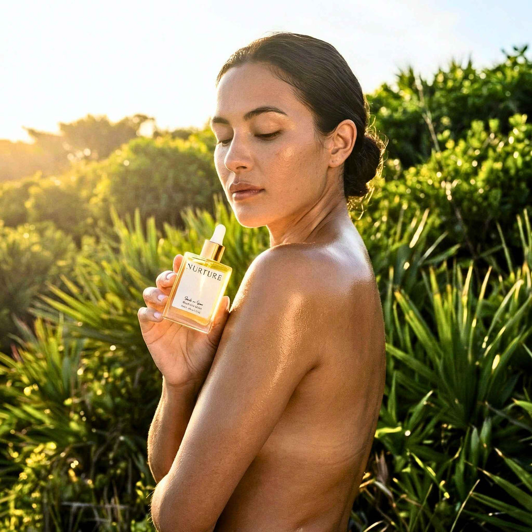 Woman holding a bottle of Salt + Sea bottle oil outdoors with greenery in the background