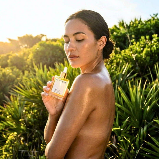 Woman holding a bottle of Salt + Sea bottle oil outdoors with greenery in the background