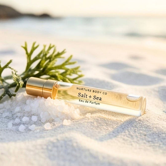 Nurture Body Co Salt + Sea Eau de Parfum bottle on sand with seaweed