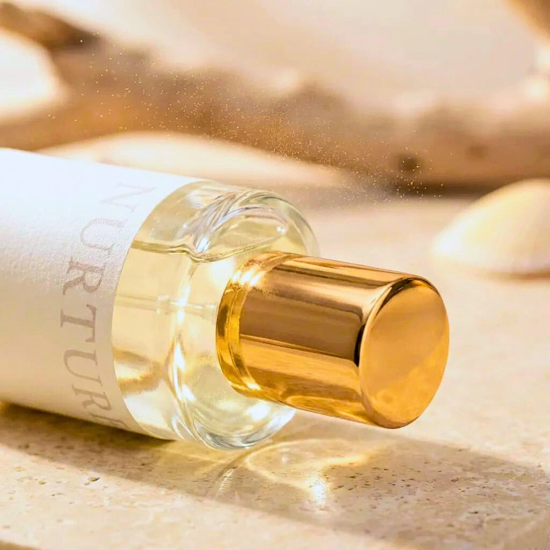 Perfume bottle with gold cap on a textured surface