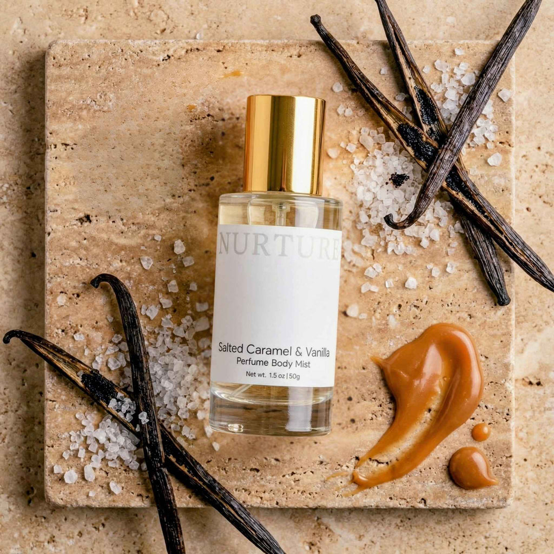 Nurture Salted Caramel &amp; Vanilla perfume body mist bottle with vanilla beans and salt on a stone surface.