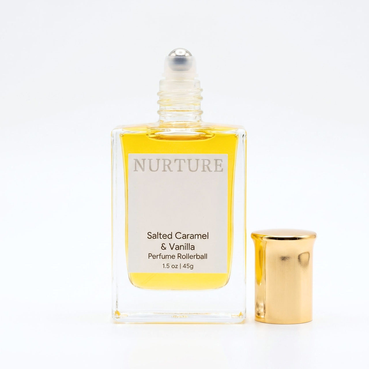 Perfume rollerball labeled 'Nurture' with gold cap on a white background