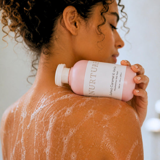 Woman holding a bottle of Salted Caramel Body Wash.