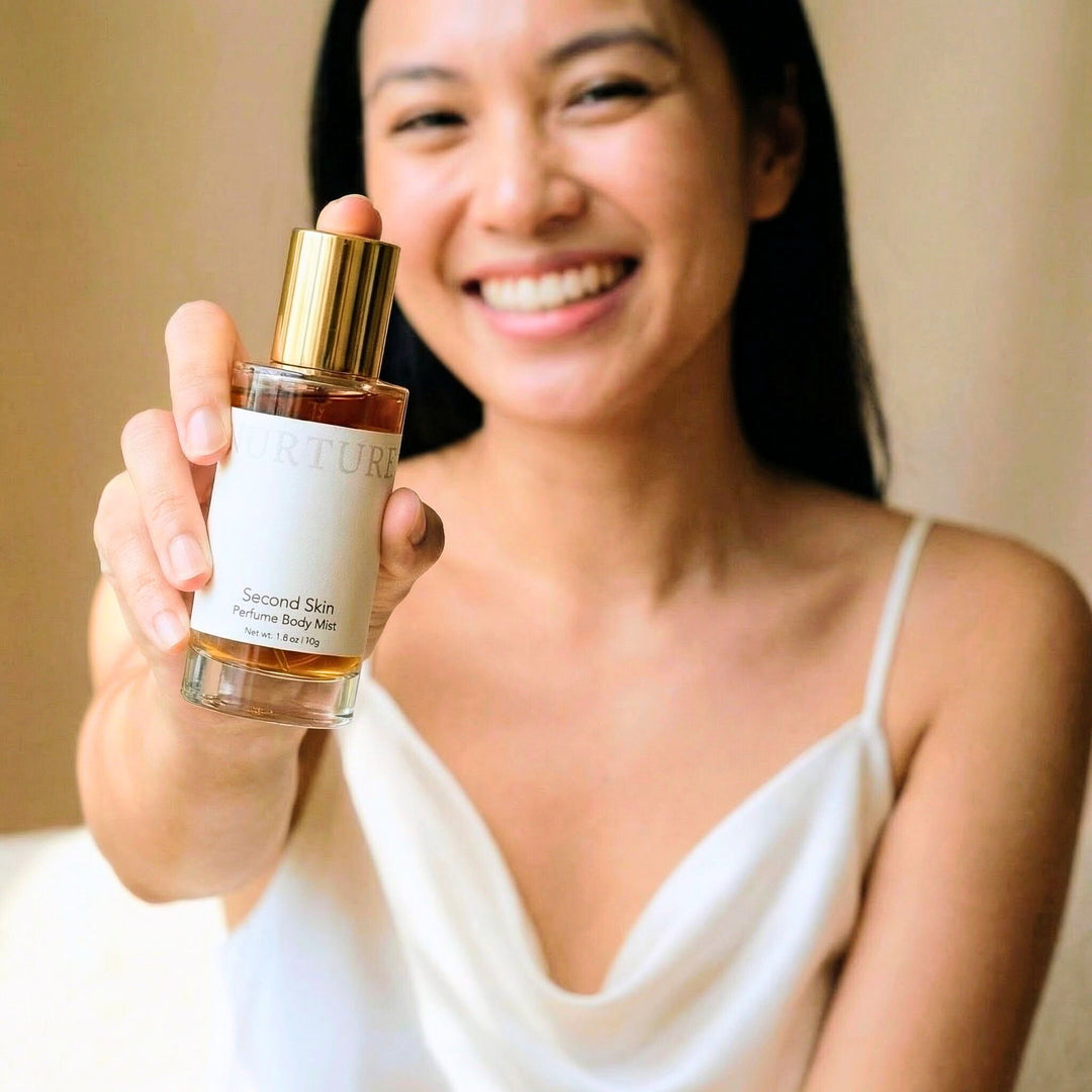 Woman holding a bottle of Nurture Body Mist with a blurred background
