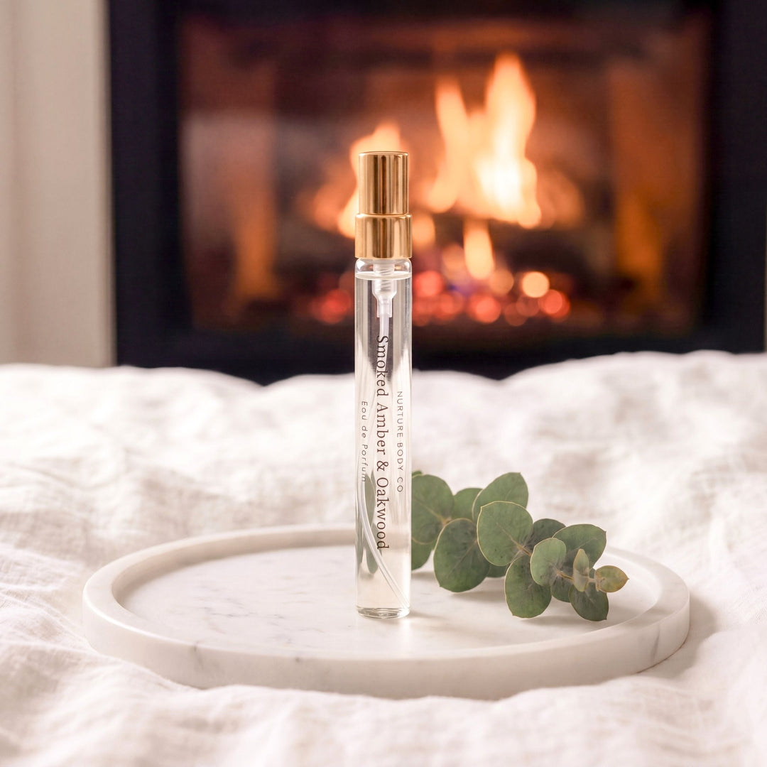 Smoked Amber &amp; Oakwood atomizer on a marble tray on a bed.