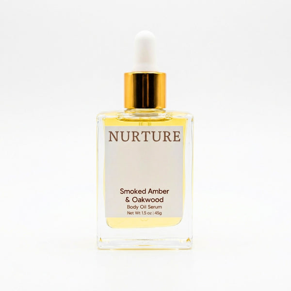 Smoked Amber & Oakwood body oil serum bottle with gold cap on a white background