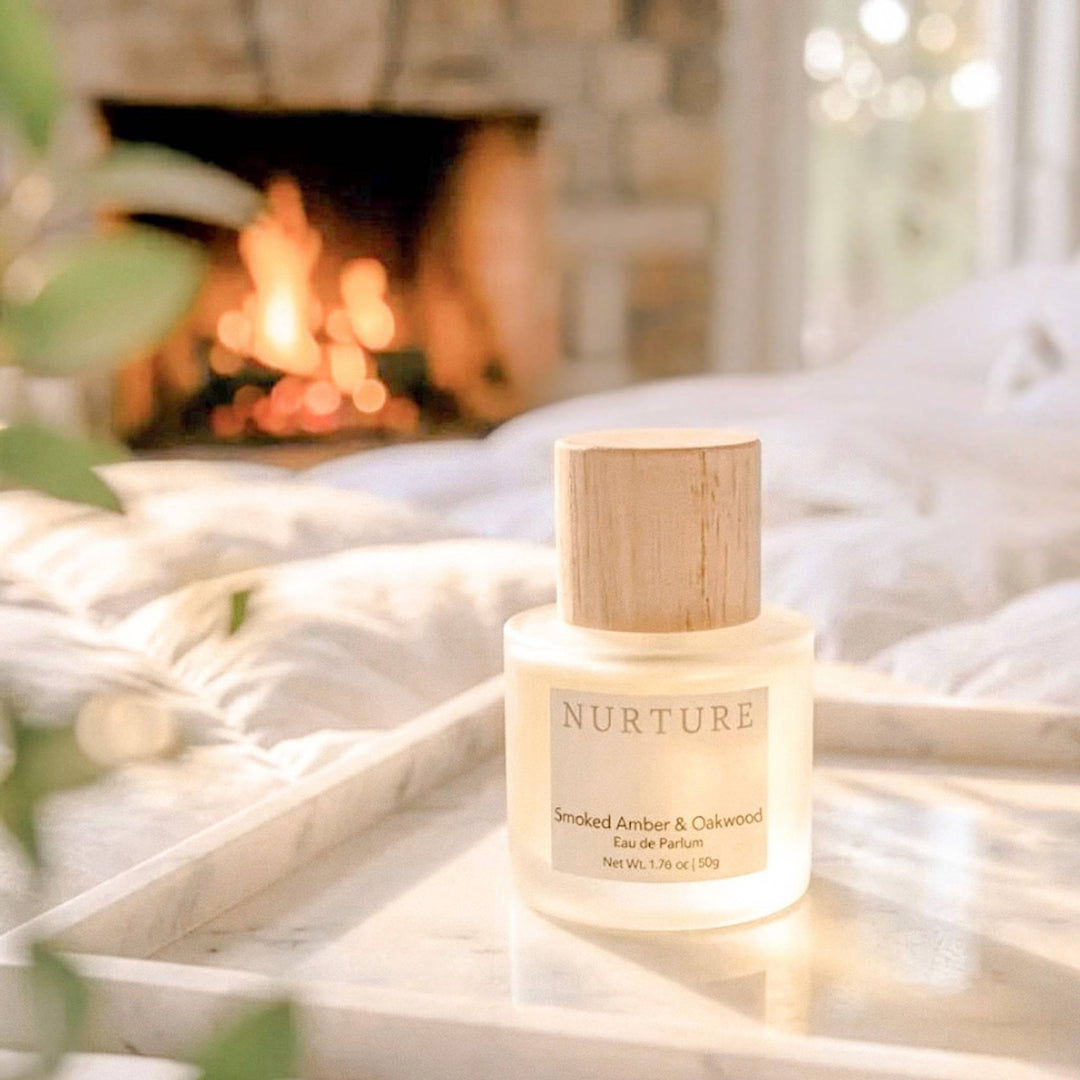 Smoked Amber &amp; Oakwood perfume on a surface with a fireplace in the background