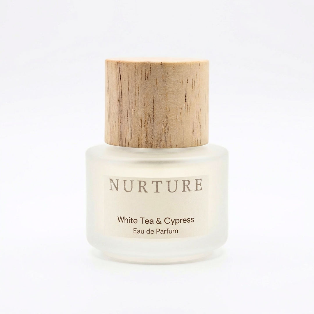 White tea and cypress perfume bottle with wooden cap on a white background