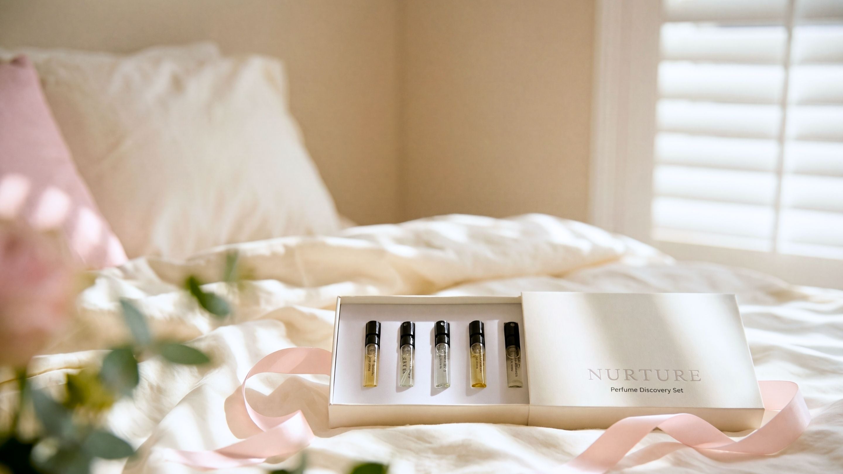 Set of perfume samples in a box on a bed with soft lighting