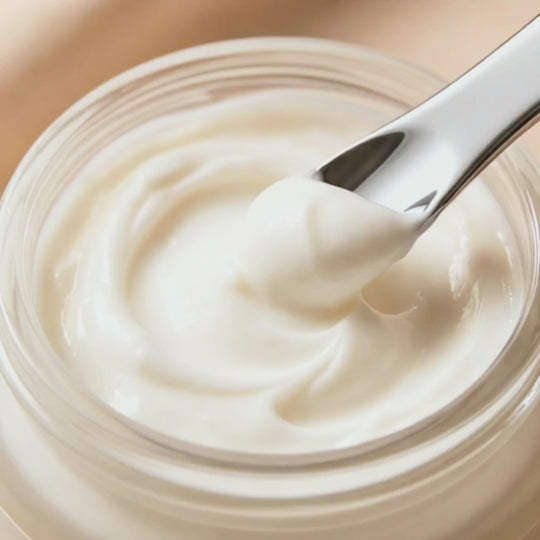 Jar of Nurture Body Butter Cream being stirred with silver spoon