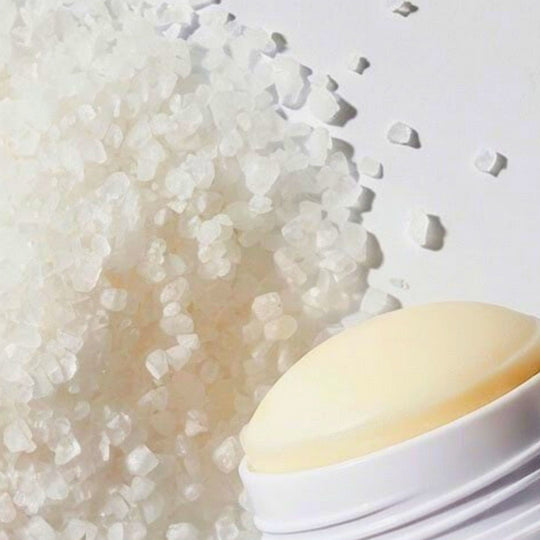 Top of Nurture deodorant against a white background with a mound of salt crystals.
